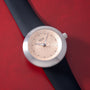 Silver-case watch with champagne textured dial featuring gold dots, black hands, and black leather strap.