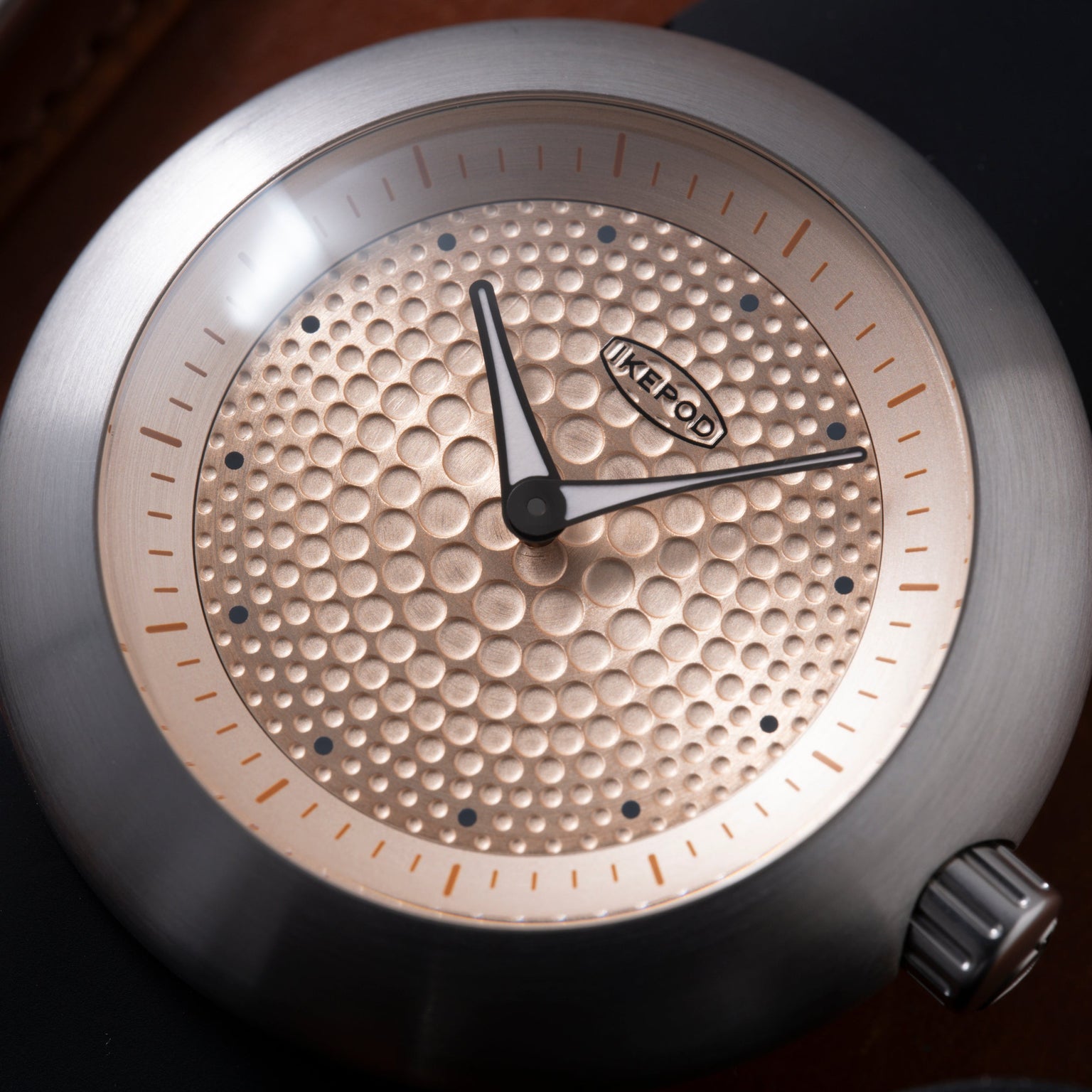 Ikepod Duopod watch with champagne dial featuring raised dot pattern, gold-tone indices, and black hands.