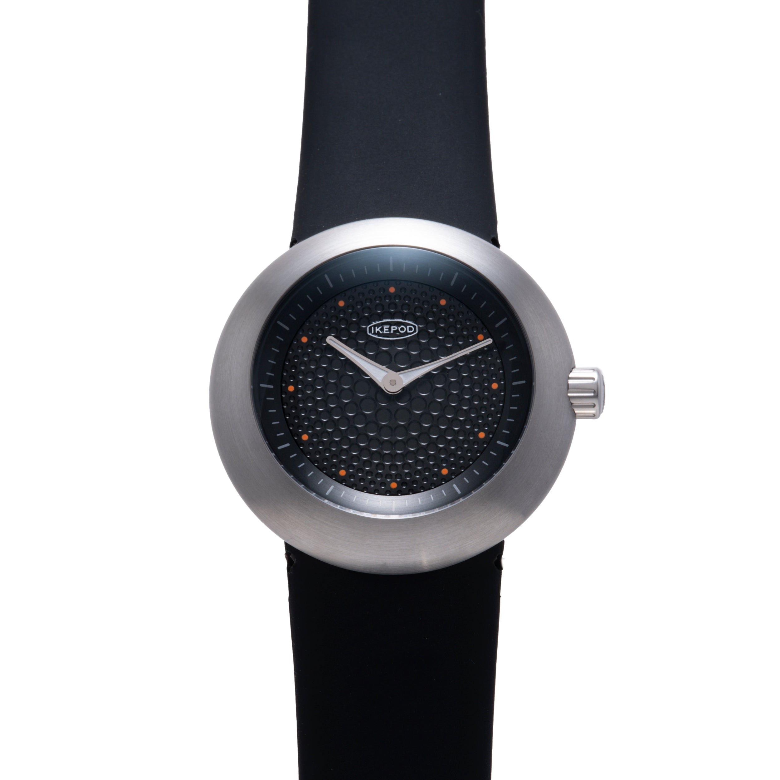 Ikepod watch with brushed metal case, black dial featuring orange dot markers, white hands, and black rubber strap.