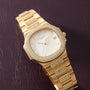 Gold-tone Patek Philippe Nautilus watch with white dial, diamond-set bezel, and matching diamond-paved bracelet links.