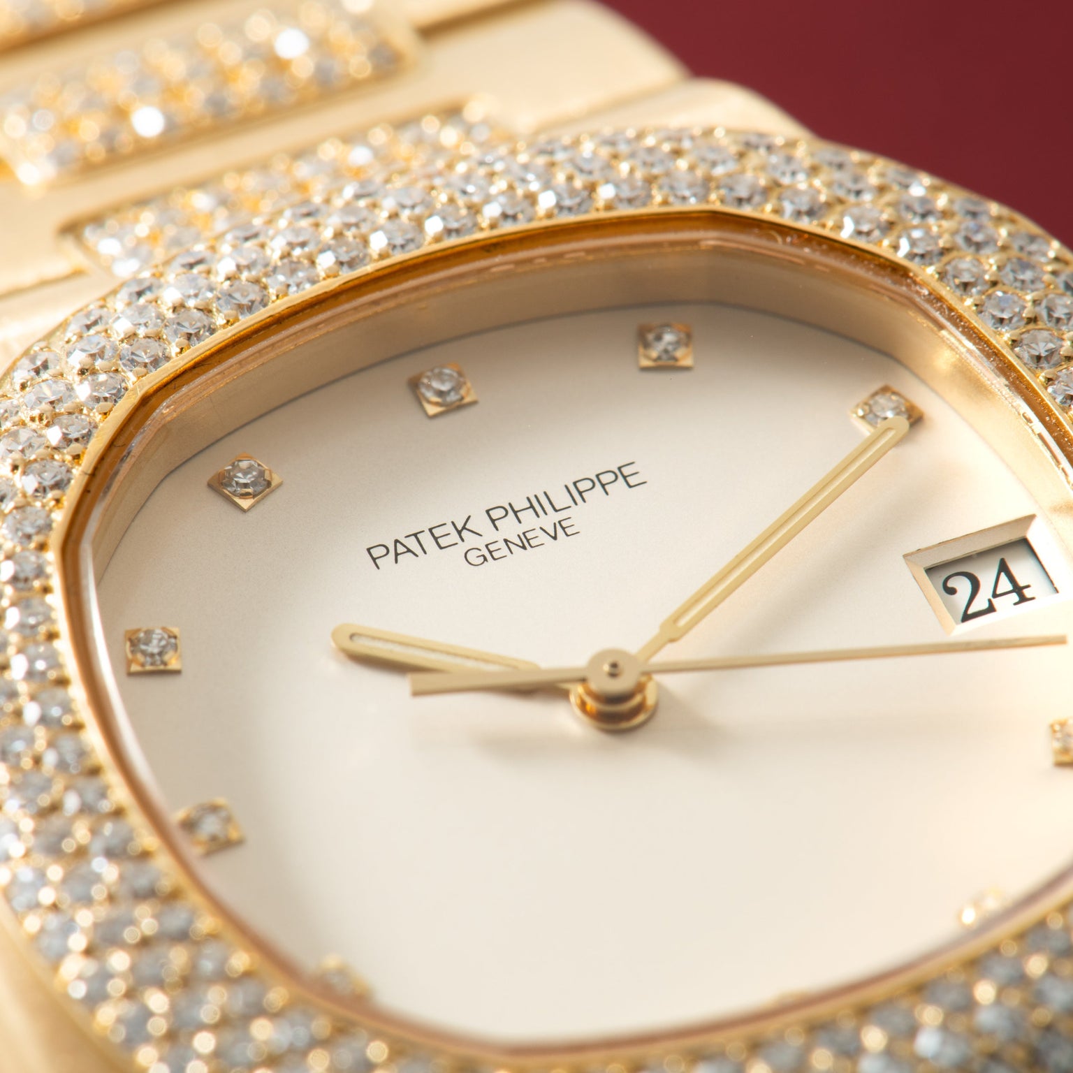 Gold-tone watch with diamond-set bezel, white dial, diamond hour markers, gold hands, and date window.