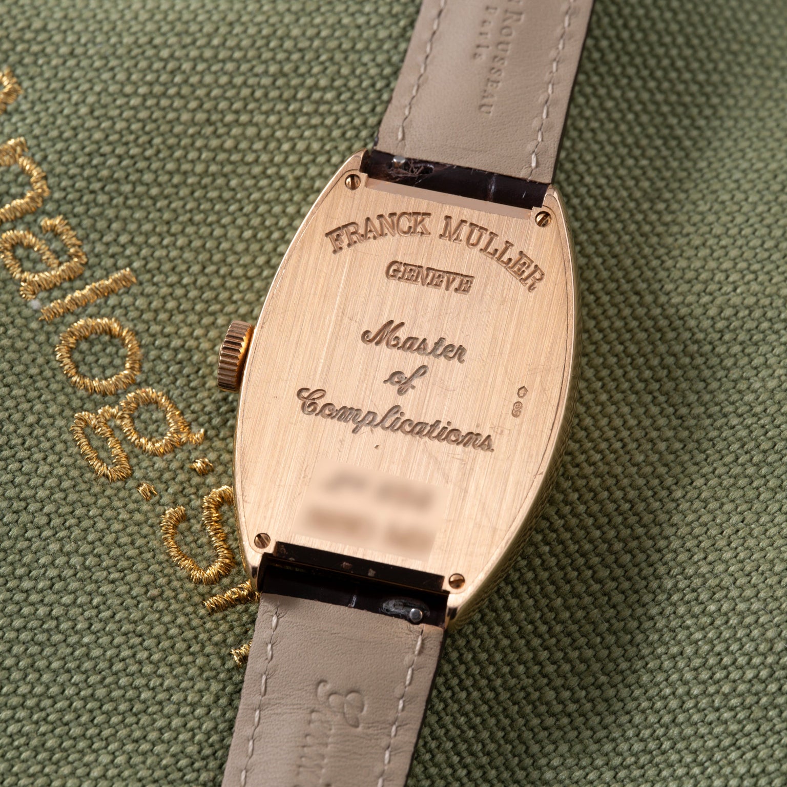 Franck Muller Master of Complications watch with rose gold tonneau case and gray leather strap.