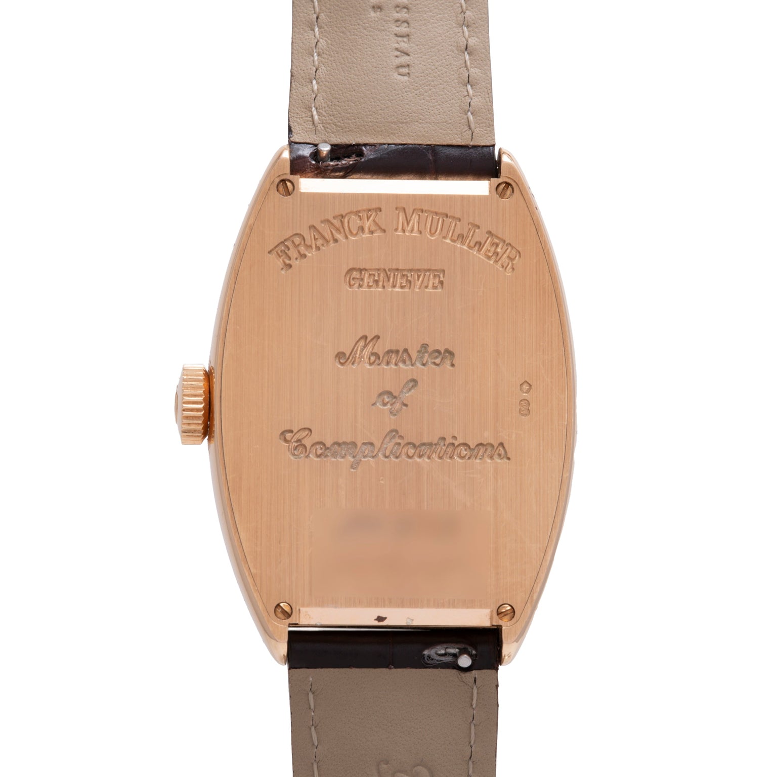 Rose gold tonneau watch case with engraved Franck Muller branding and beige leather strap with black accents.