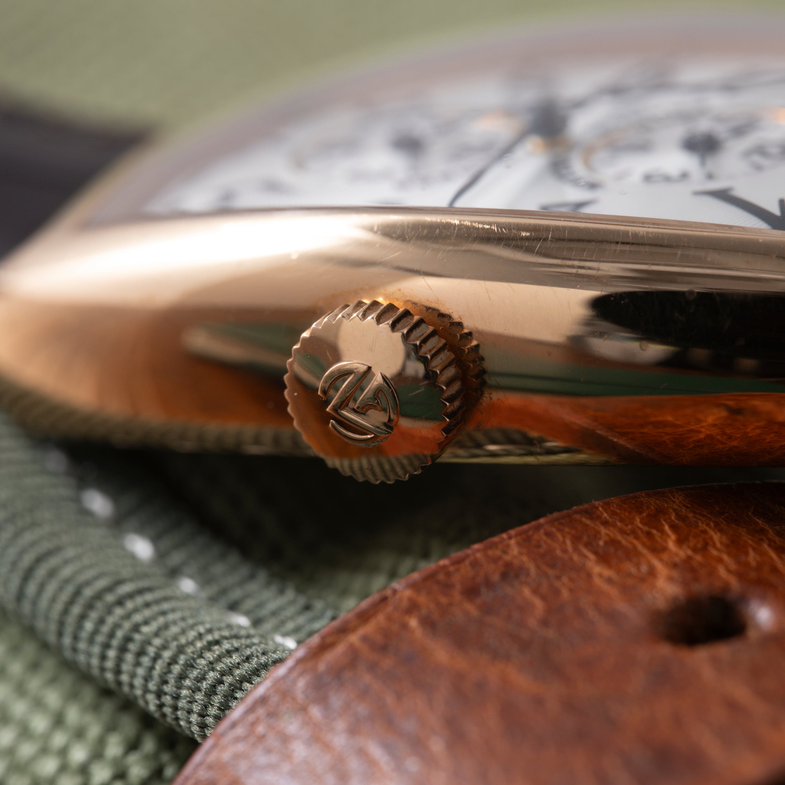 Close-up of Franck Muller Master Banker watch crown and case band with blurred dial in background.