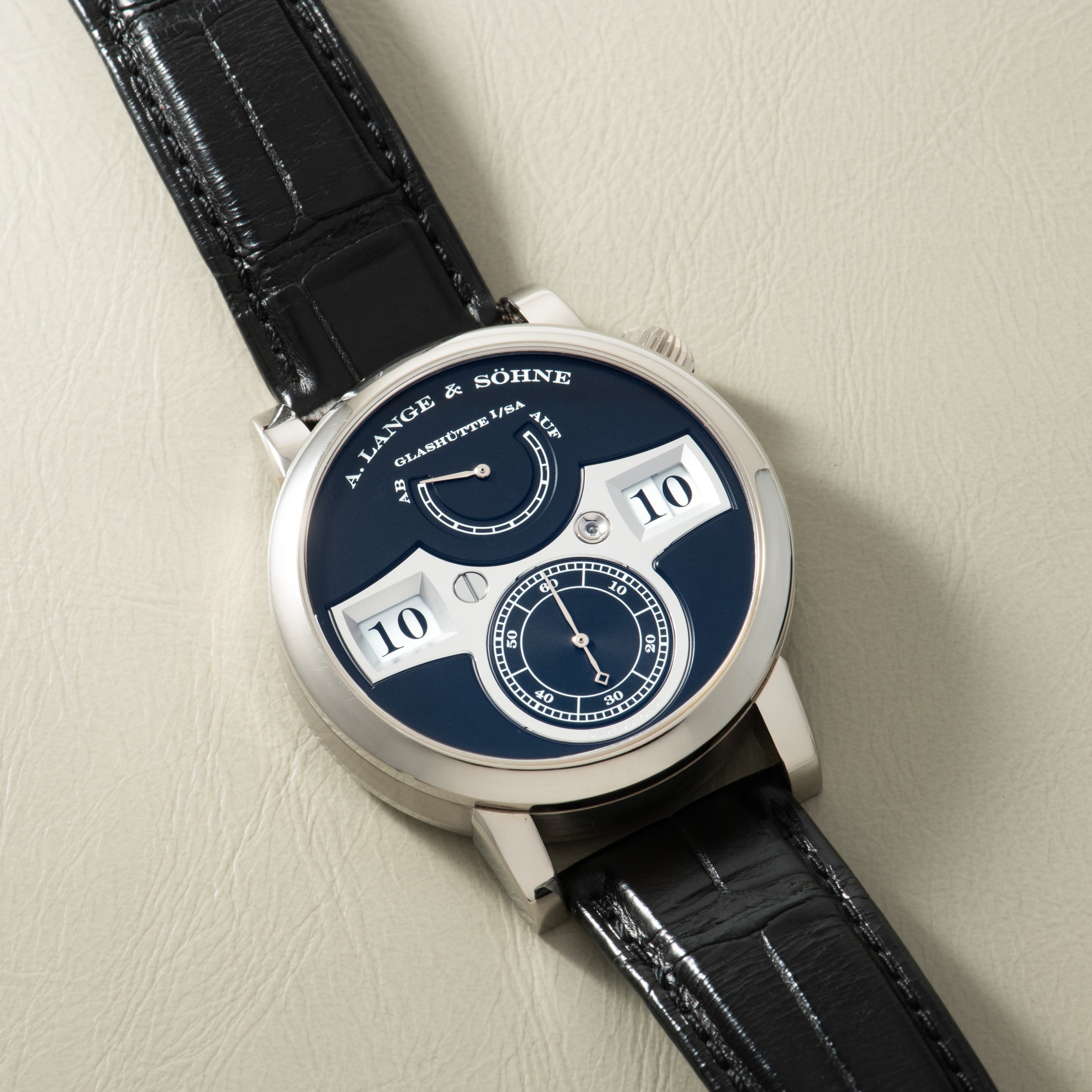 A. Lange & Söhne Zeitwerk watch with blue dial, digital time display windows, subsidiary dial, and black leather strap.