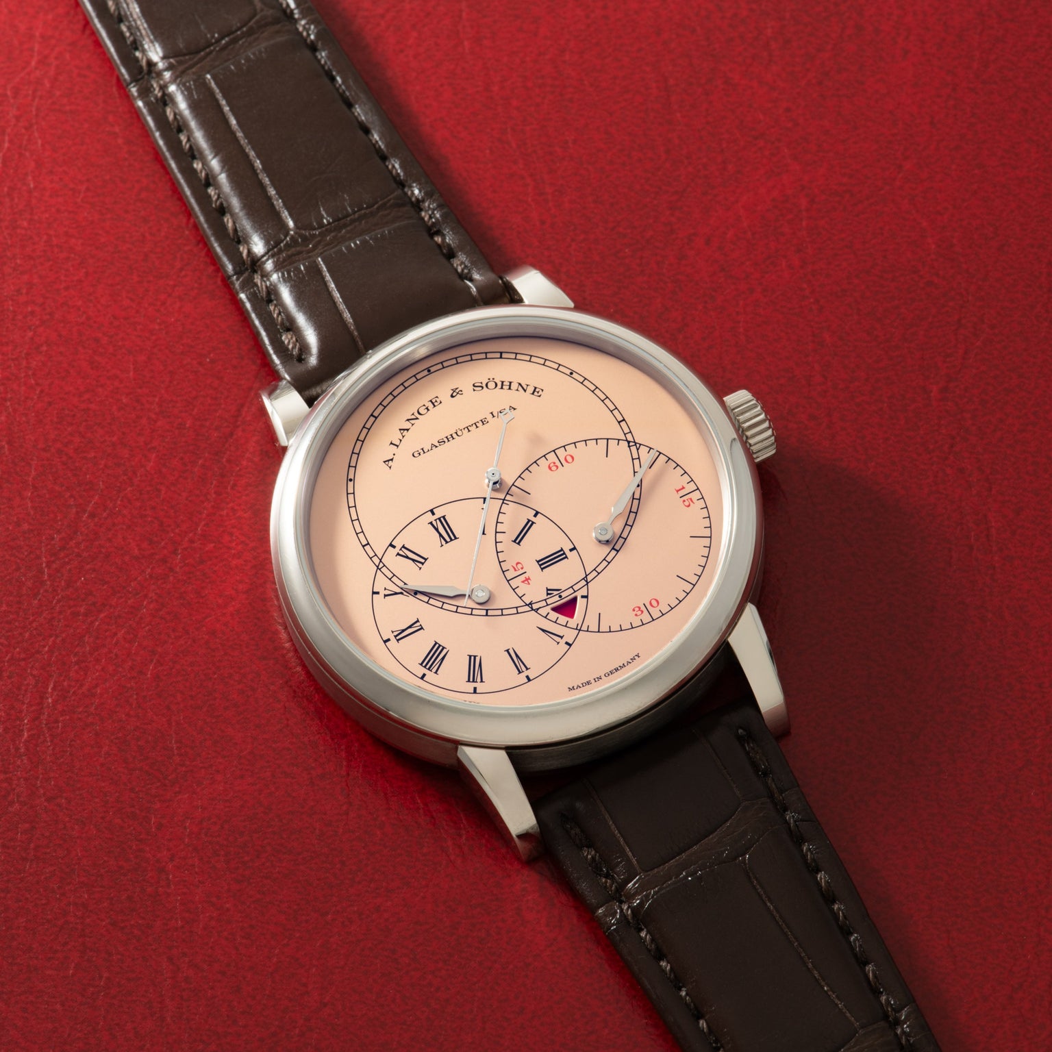 A. Lange & Söhne luxury watch with cream dial, Roman numerals, dual subdials, and black crocodile leather strap.