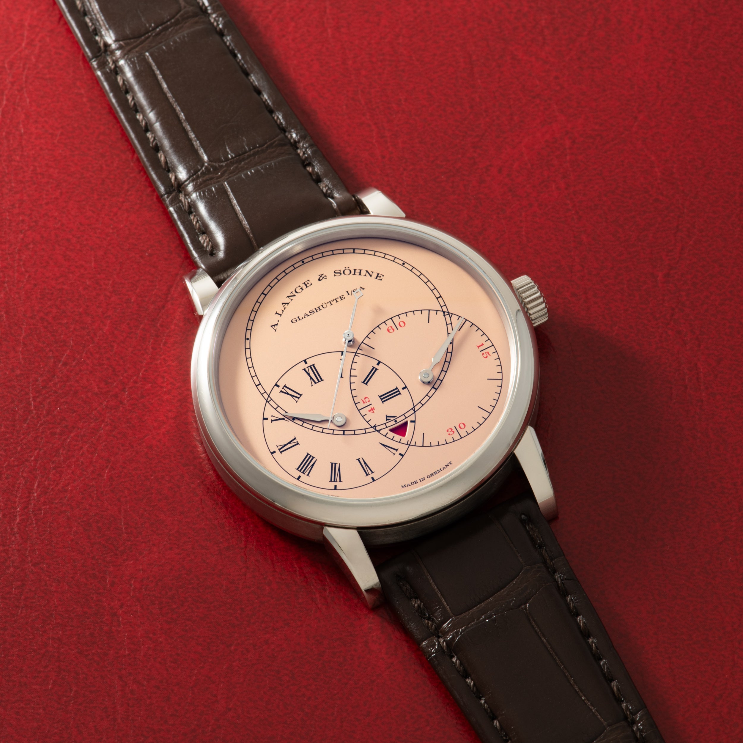 A. Lange & Söhne luxury watch with cream dial, Roman numerals, dual subdials, and black crocodile leather strap.