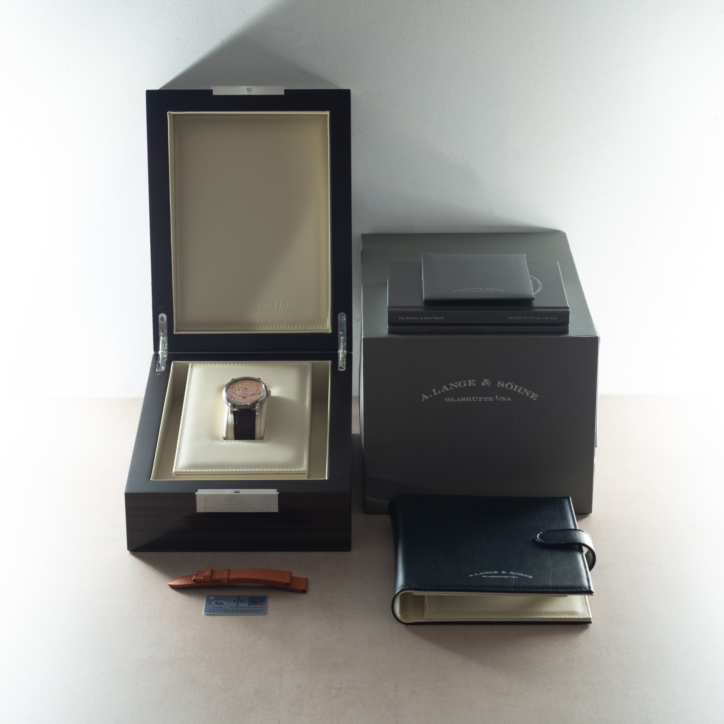 A. Lange & Söhne Jumping Seconds watch with rose gold case and black leather strap displayed in open black box with accessori