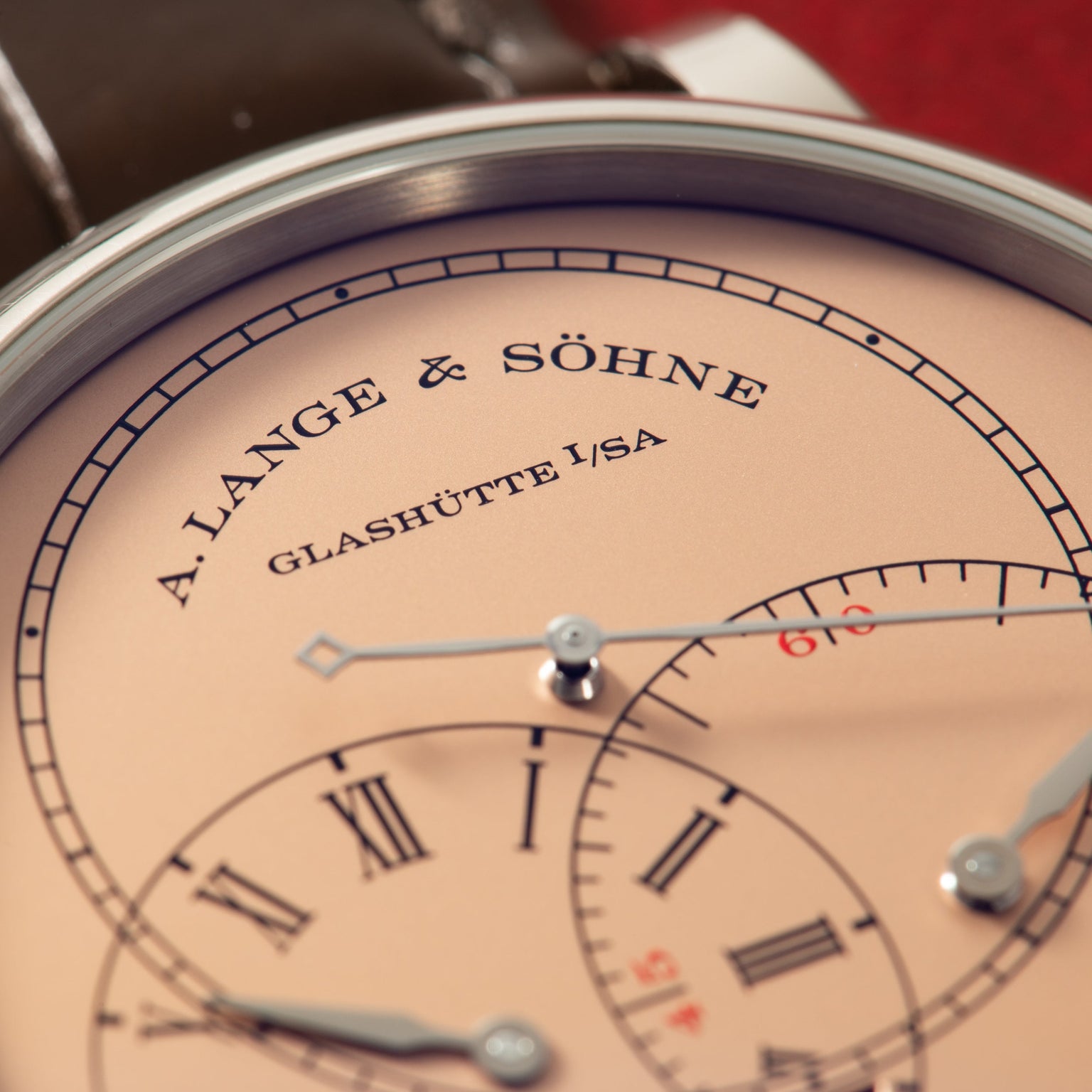 A. Lange & Söhne watch dial with cream face, Roman numerals, jumping seconds indicator, and steel hands against dark leather