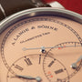 A. Lange & Söhne watch dial with cream face, Roman numerals, jumping seconds indicator, and steel hands against dark leather