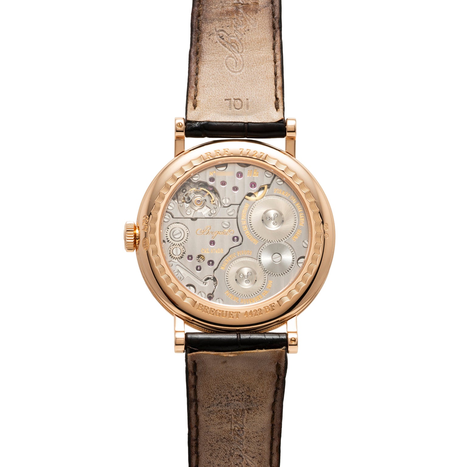 Rose gold round watch with visible movement through caseback, black leather strap, and exposed gears and balance wheel.