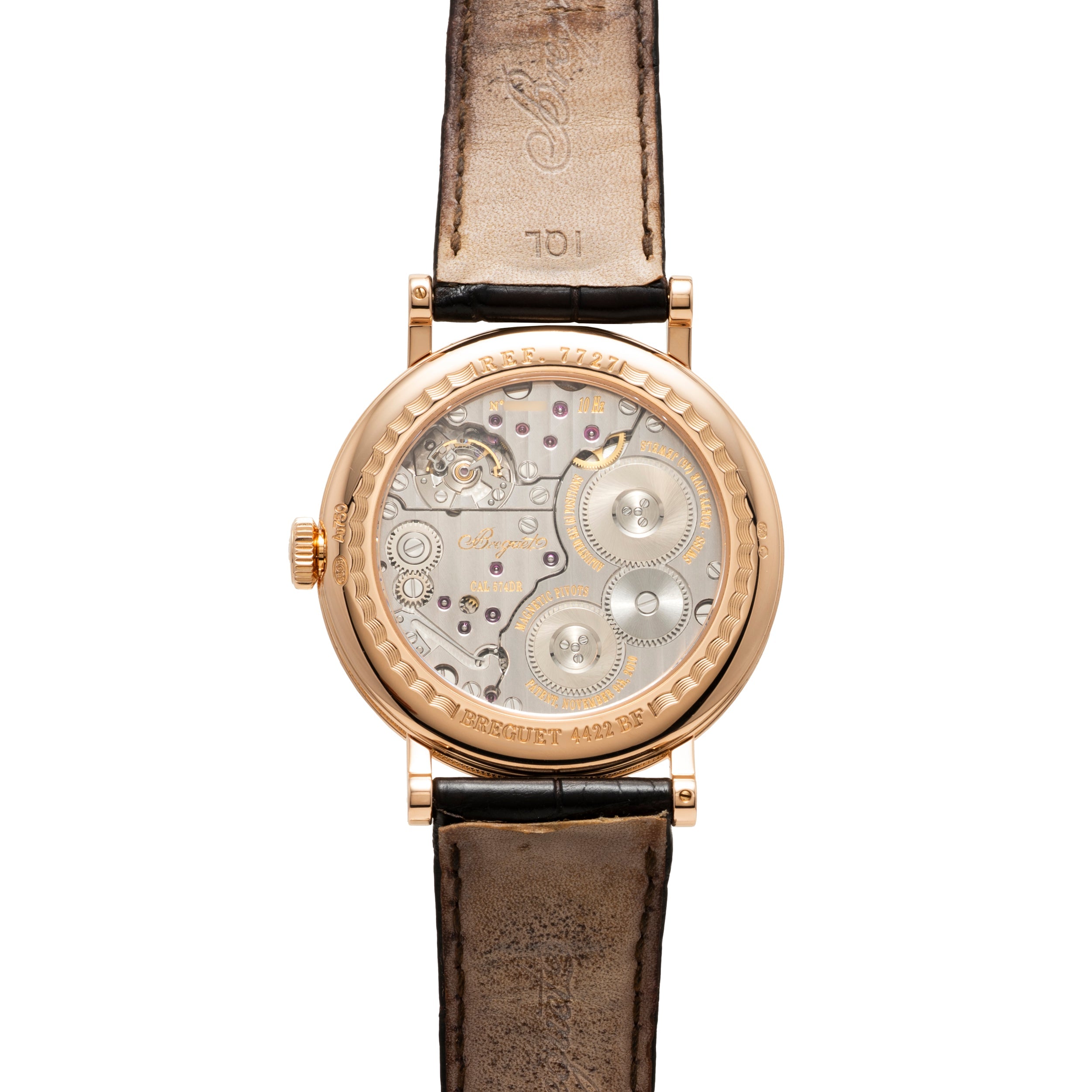 Rose gold round watch with visible movement through caseback, black leather strap, and exposed gears and balance wheel.