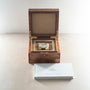 Breguet Classique watch with white dial and leather strap in open wood box with accompanying documentation.