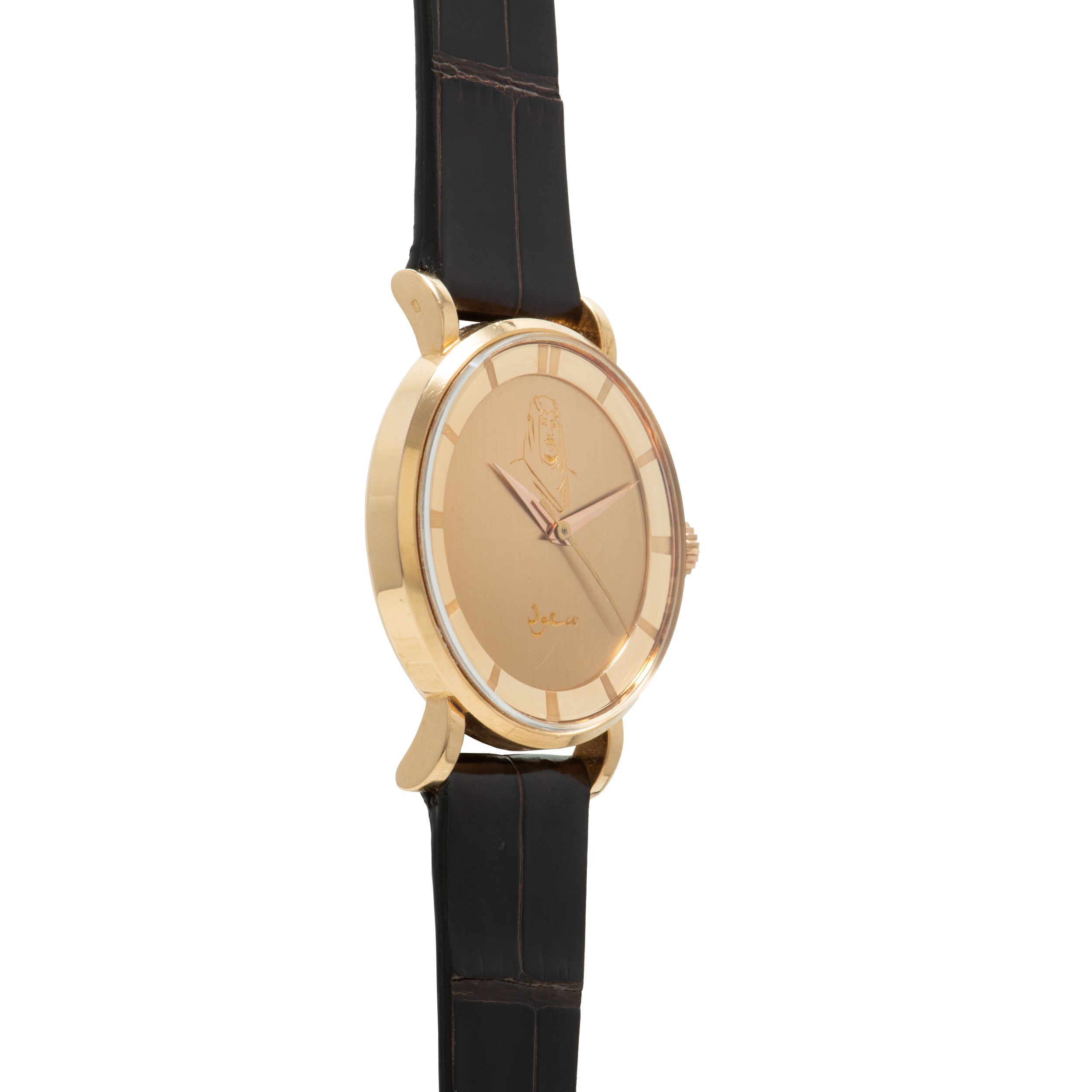Gold-toned oval watch with champagne dial, engraved emblem, and black crocodile leather strap.