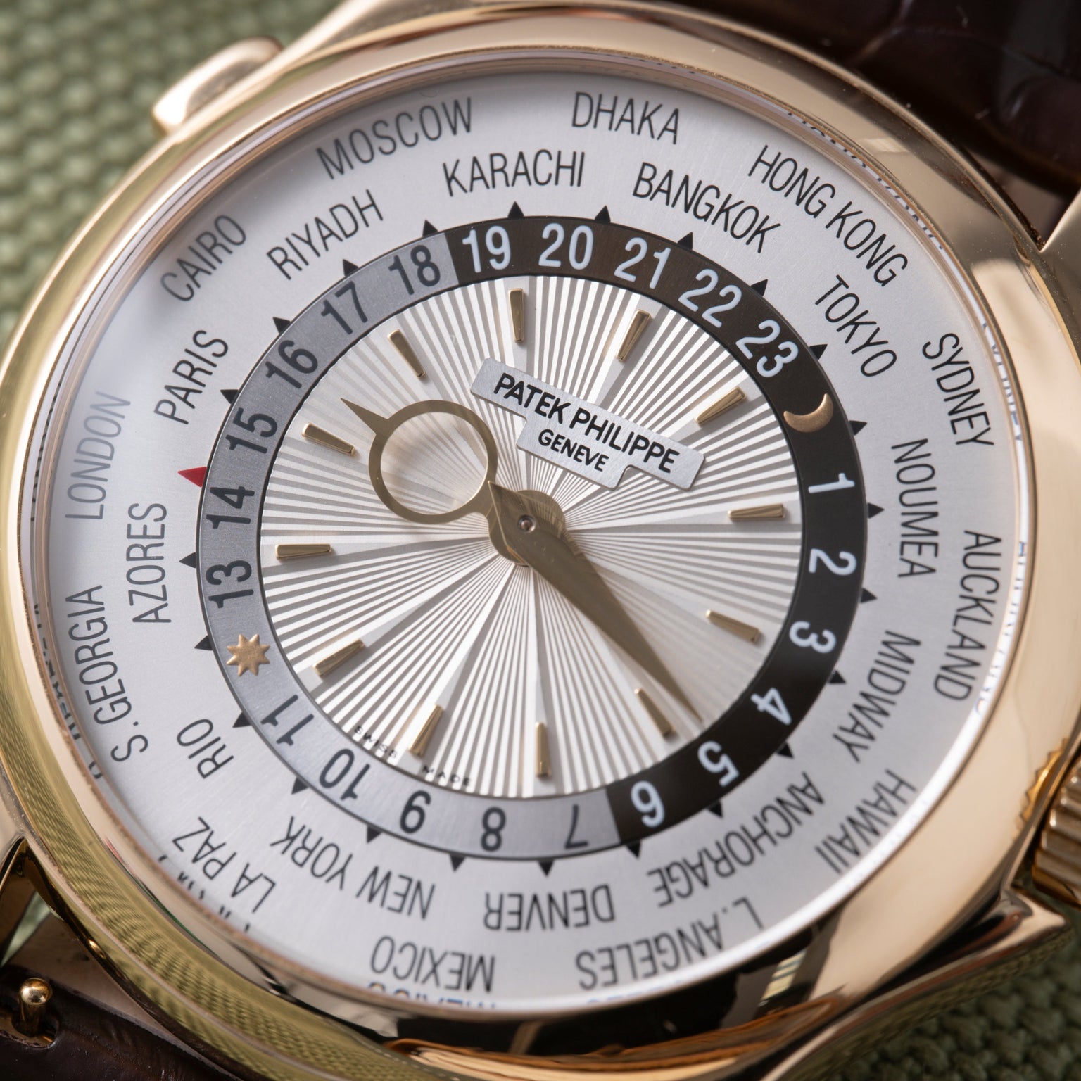 Patek Philippe World Time watch with white dial, city ring, and 24-hour GMT bezel on dark leather strap.
