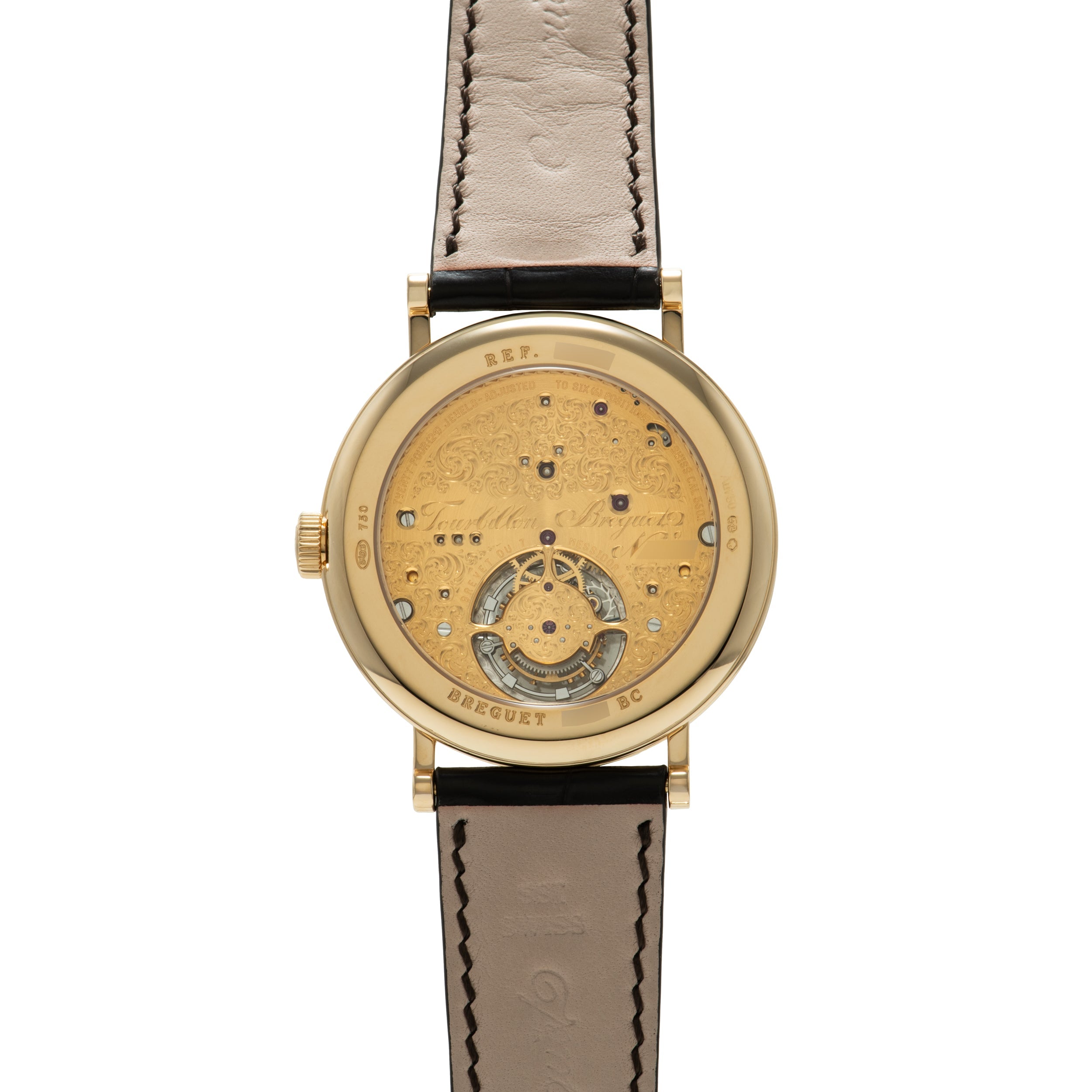 Gold-tone round watch with champagne dial, visible tourbillon at bottom, blue hour markers, and black leather strap.