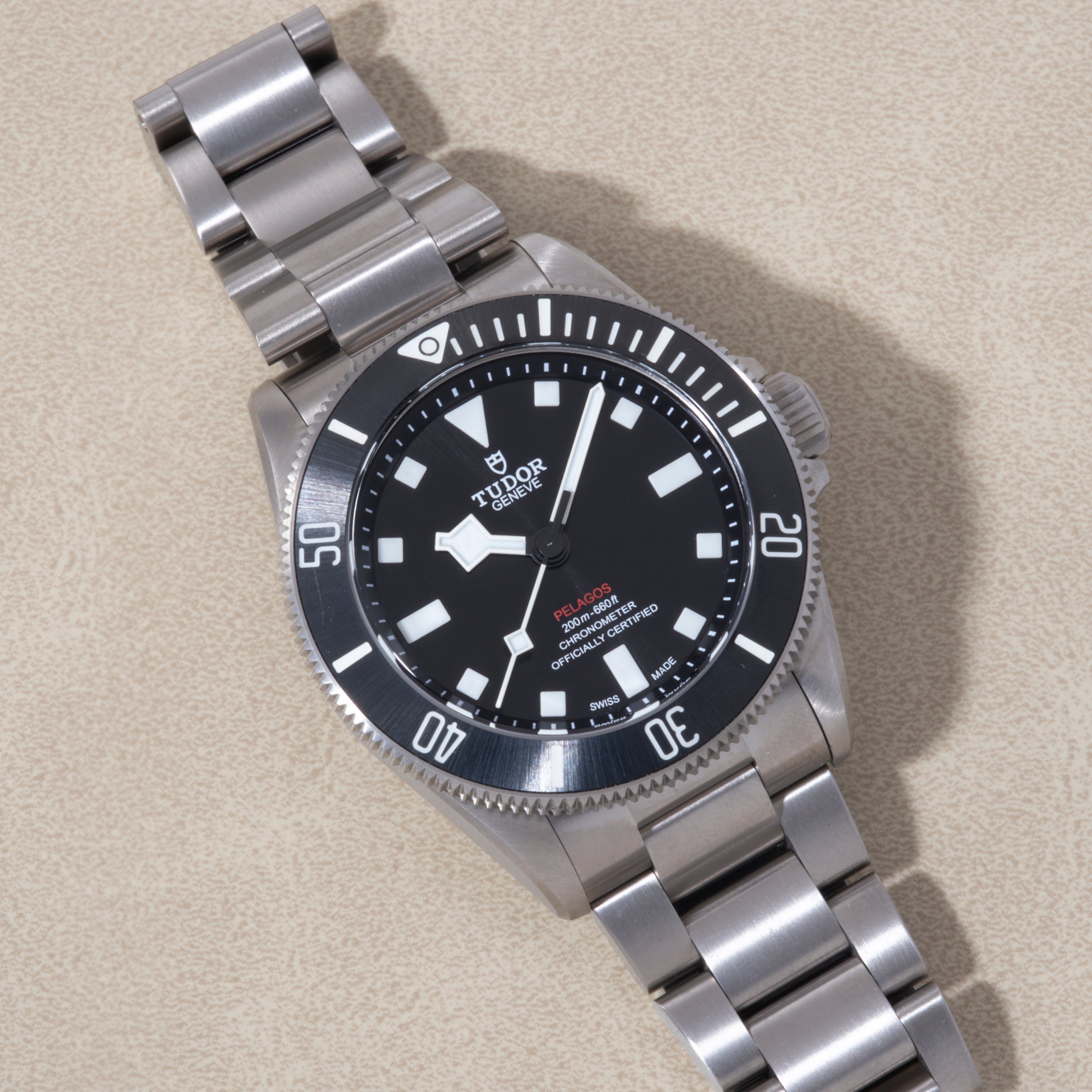 Tudor Pelagos 39 stainless steel dive watch with black dial, white hour markers, and matching metal bracelet.