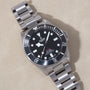 Tudor Pelagos 39 stainless steel dive watch with black dial, white hour markers, and matching metal bracelet.