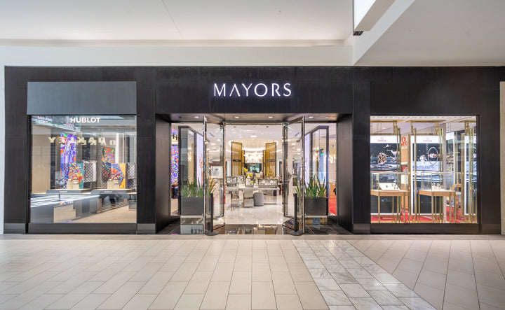 Exterior view of a MAYORS jewelry store in a mall, with glass doors and displays inside.