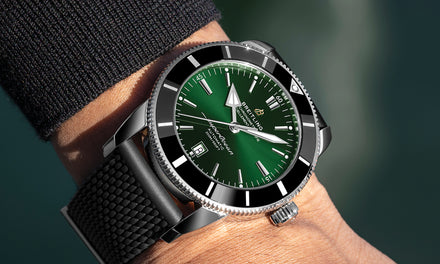 Breitling SuperOcean with a green dial on a wrist