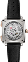 Tag Heuer Monaco chronograph with square steel case, visible movement on back, black perforated leather strap, and rose gold 