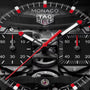TAG Heuer Monaco Evergraph watch face with black dial, red and white hands, visible gears, and tachymeter scale.