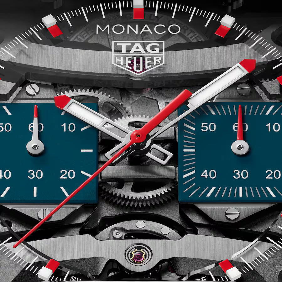 TAG Heuer Monaco Evergraph watch face with red and white hands, teal subdials, and visible internal mechanical components.