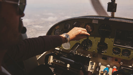 Pilot flying in the air with his Rolex CPO watch