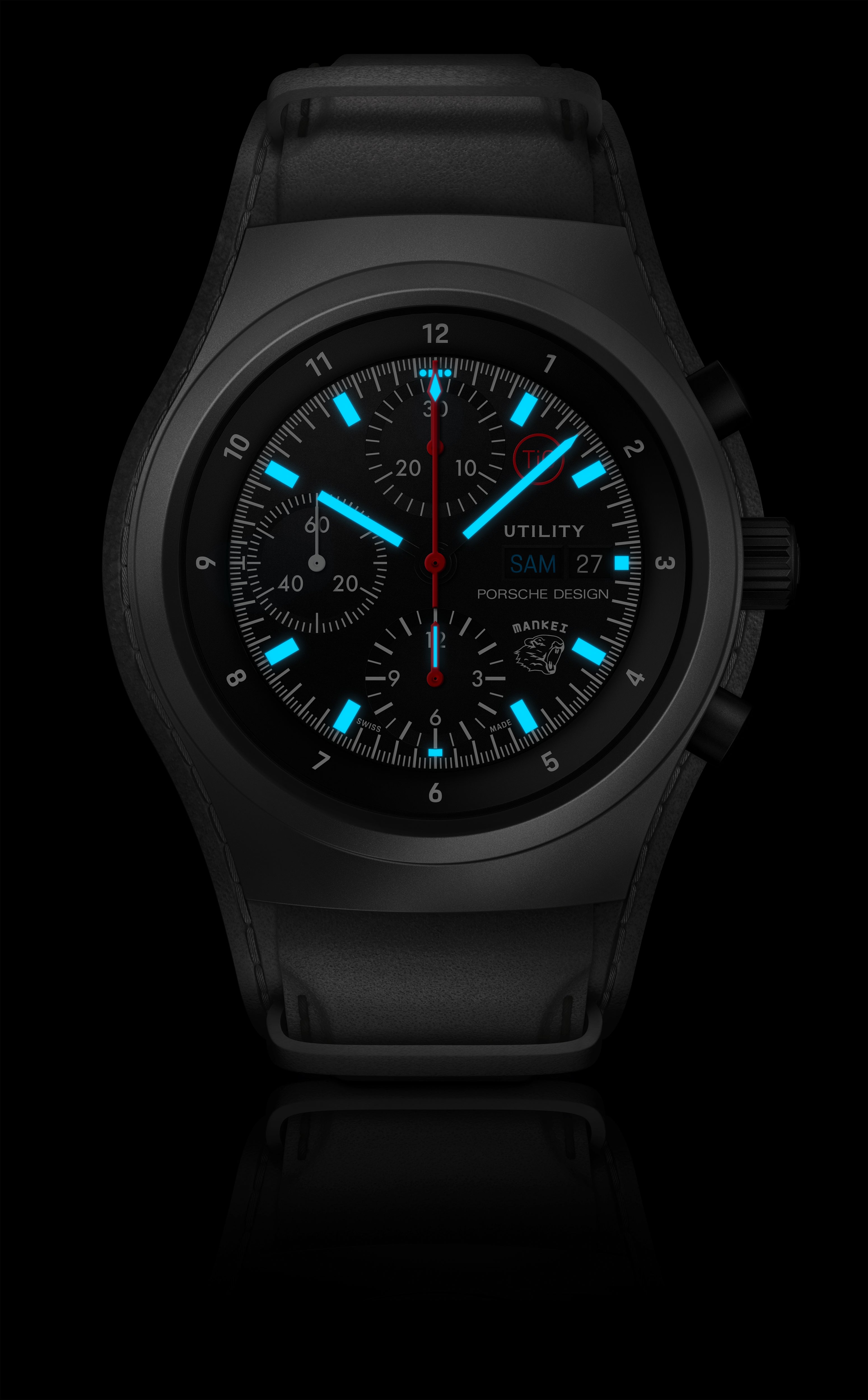 The Porsche Design Chronograph 1 Utility Limited Edition is a black wristwatch with blue luminous markers and hands, featuring date, day, and chronograph functions.