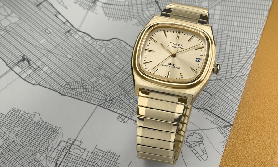 Gold timex watch on a map