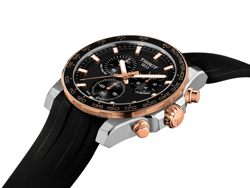 42mm stainless steel chronograph watch with black dial, rose gold and silver case, black rubber strap, and tachymeter bezel.
