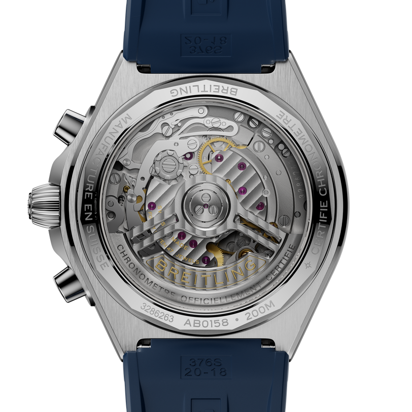 Stainless steel watch with visible mechanical movement, purple jewels, gold accents, and blue rubber strap shown from case ba