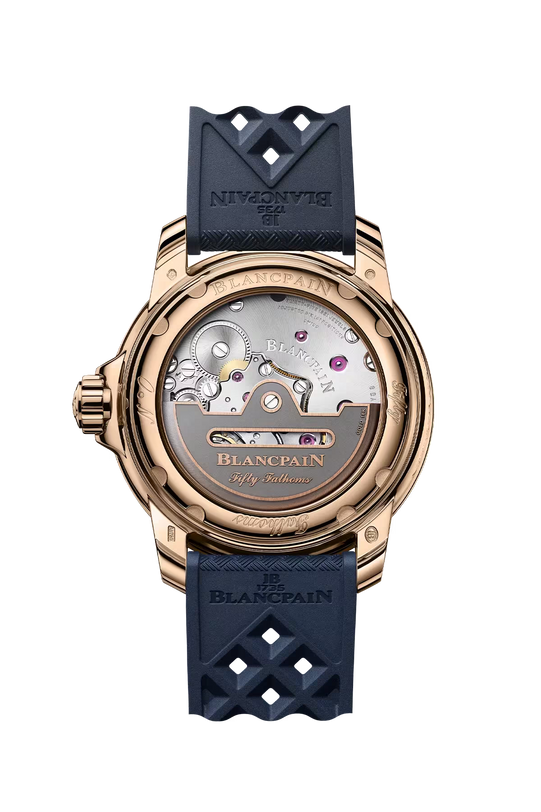 Rose gold watch with exposed movement caseback, dark blue sail-canvas strap with geometric cutouts, and visible mechanical co