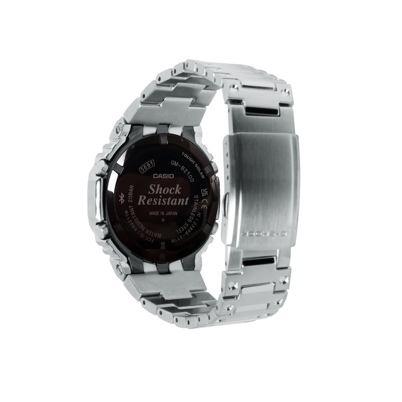 Silver stainless steel G-Shock digital watch with black round face and metal band shown from side view.