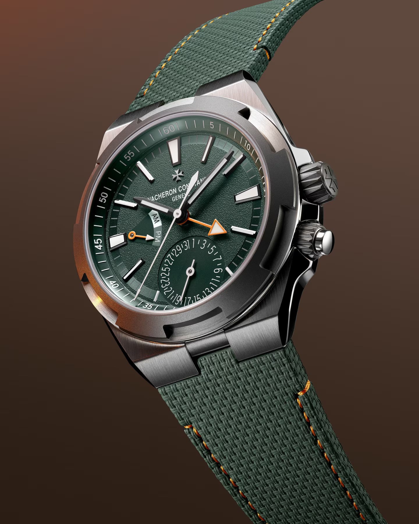 Stainless steel watch with green dial, dual time subdial, orange accents, and matching green fabric strap with orange stitchi