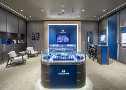 Modern Grand Seiko watch boutique interior with glass display cases and elegant seating area.