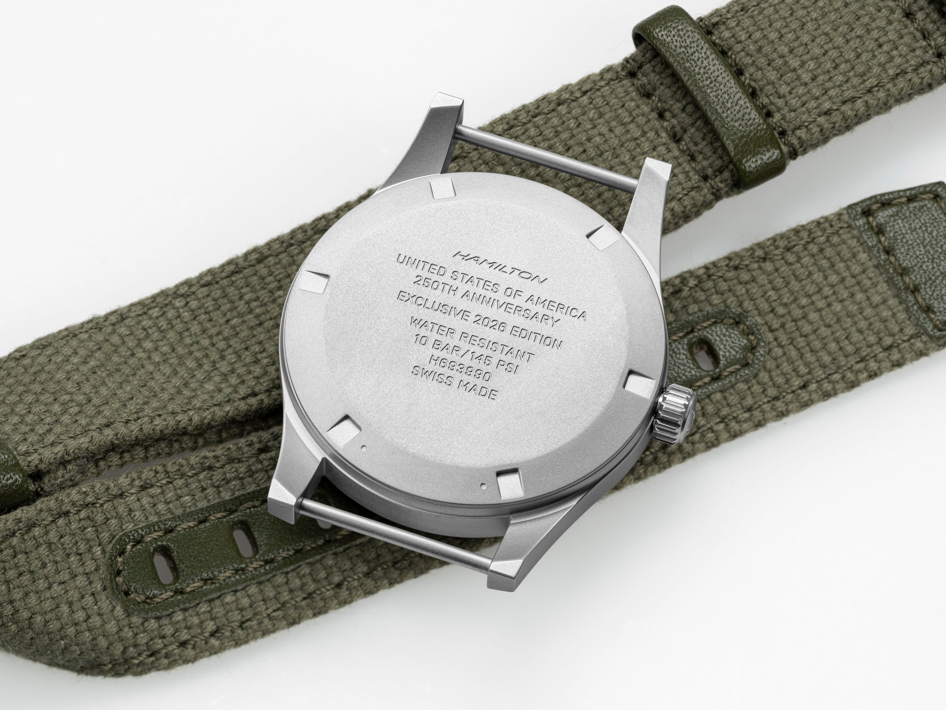 Close-up of a watch with a green strap on a white background