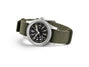 Watch with green strap and black dial on a white background