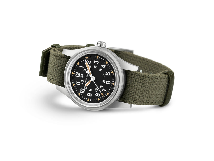 Watch with green strap and black dial on a white background