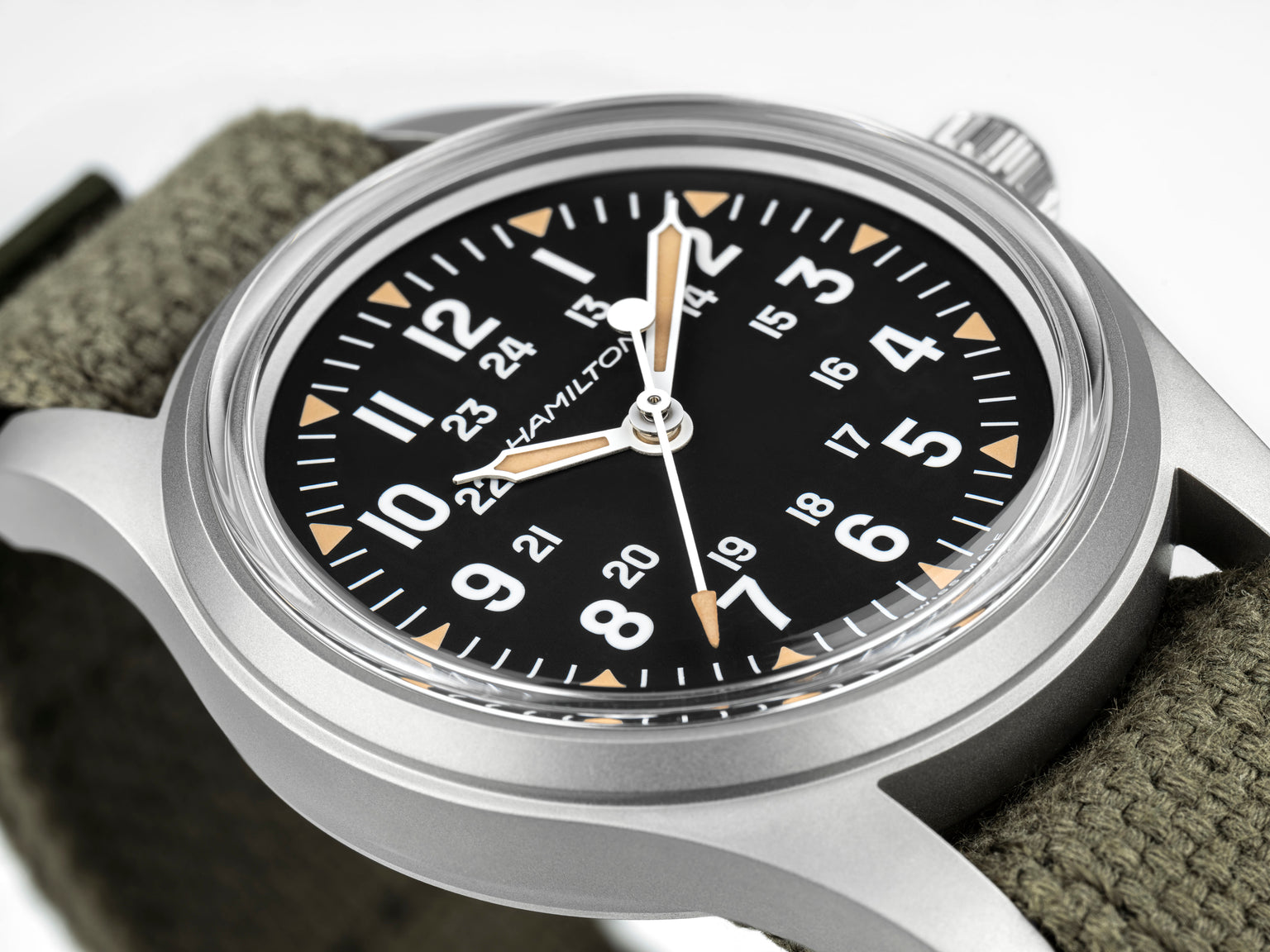 Hamilton watch with black dial and green strap on a white background