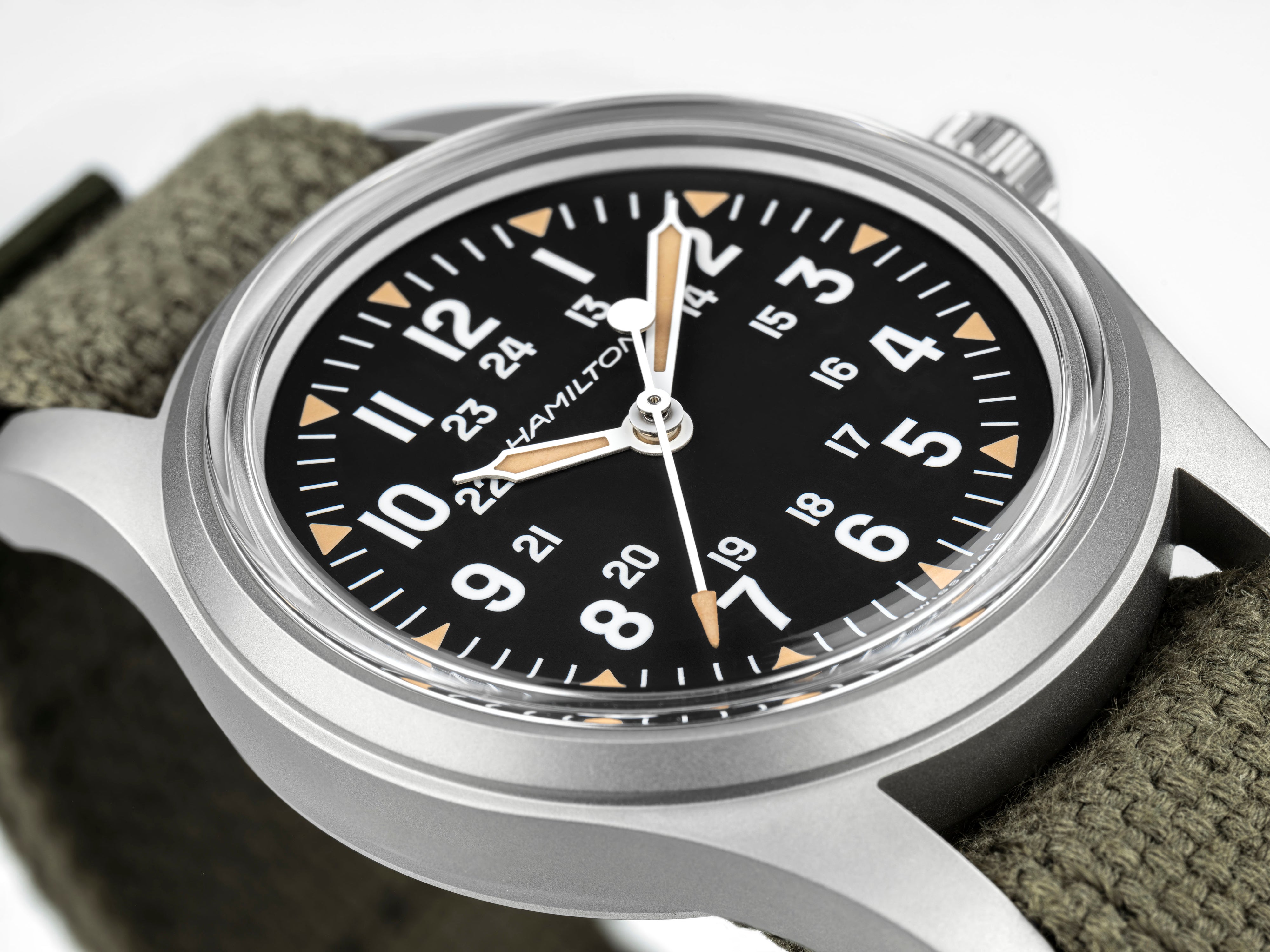 Hamilton watch with black dial and green strap on a white background