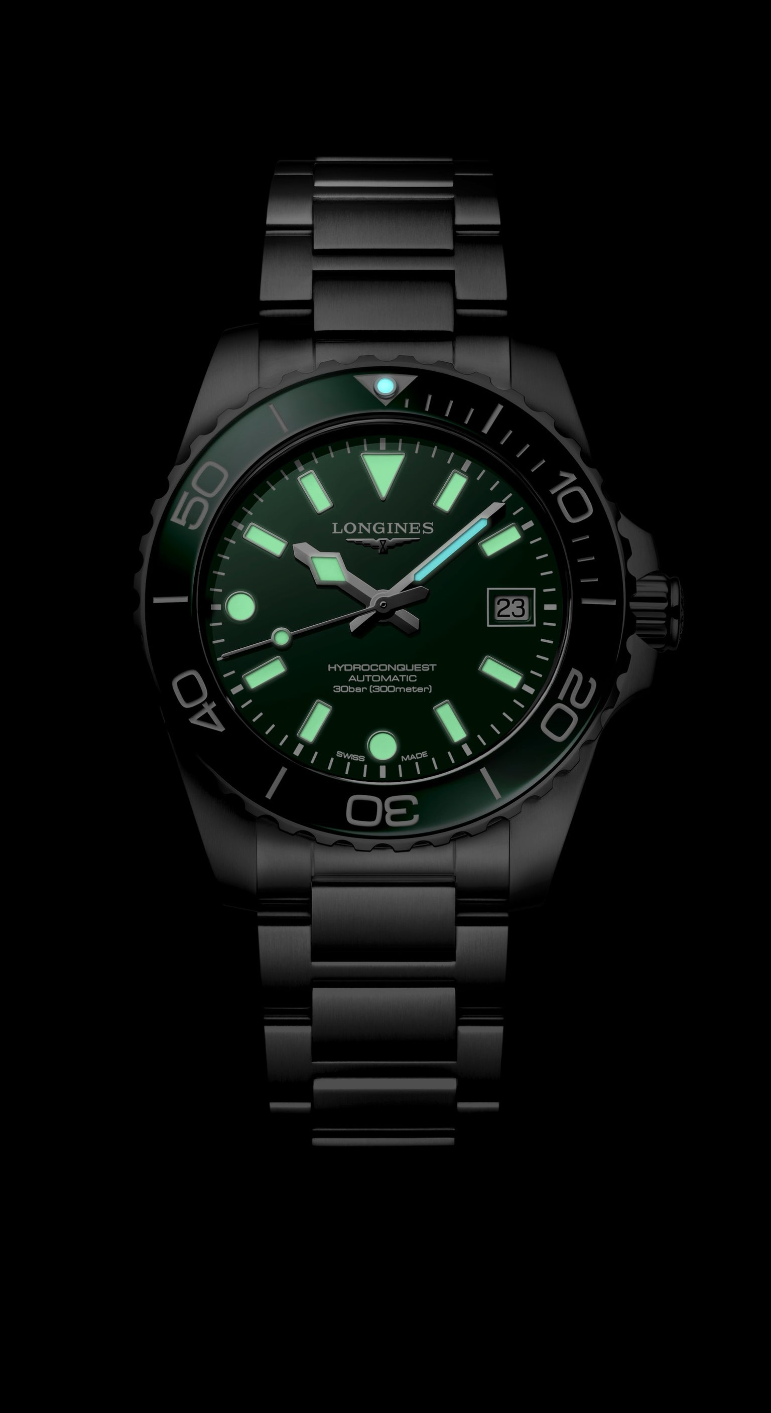 Black wristwatch with green glowing face on a black background