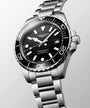 Longines watch with black dial and silver bracelet on a light gray background