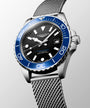 Longines watch with blue bezel and silver mesh band on gray background