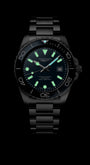 Black wristwatch with glowing green face on a black background