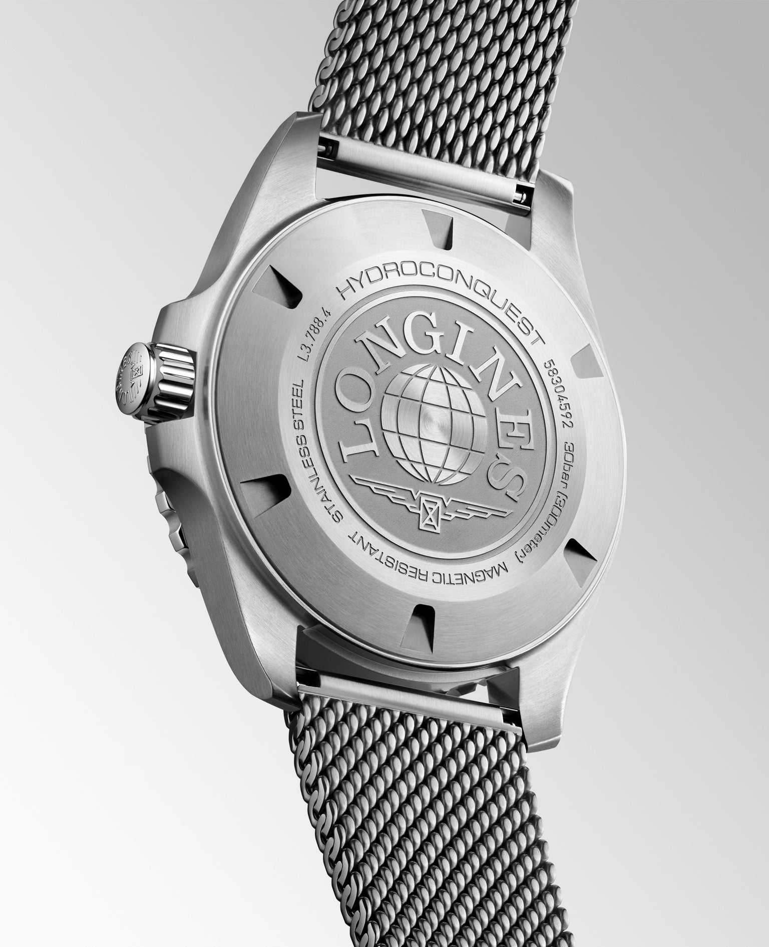 Silver watch with mesh band on a light gray background