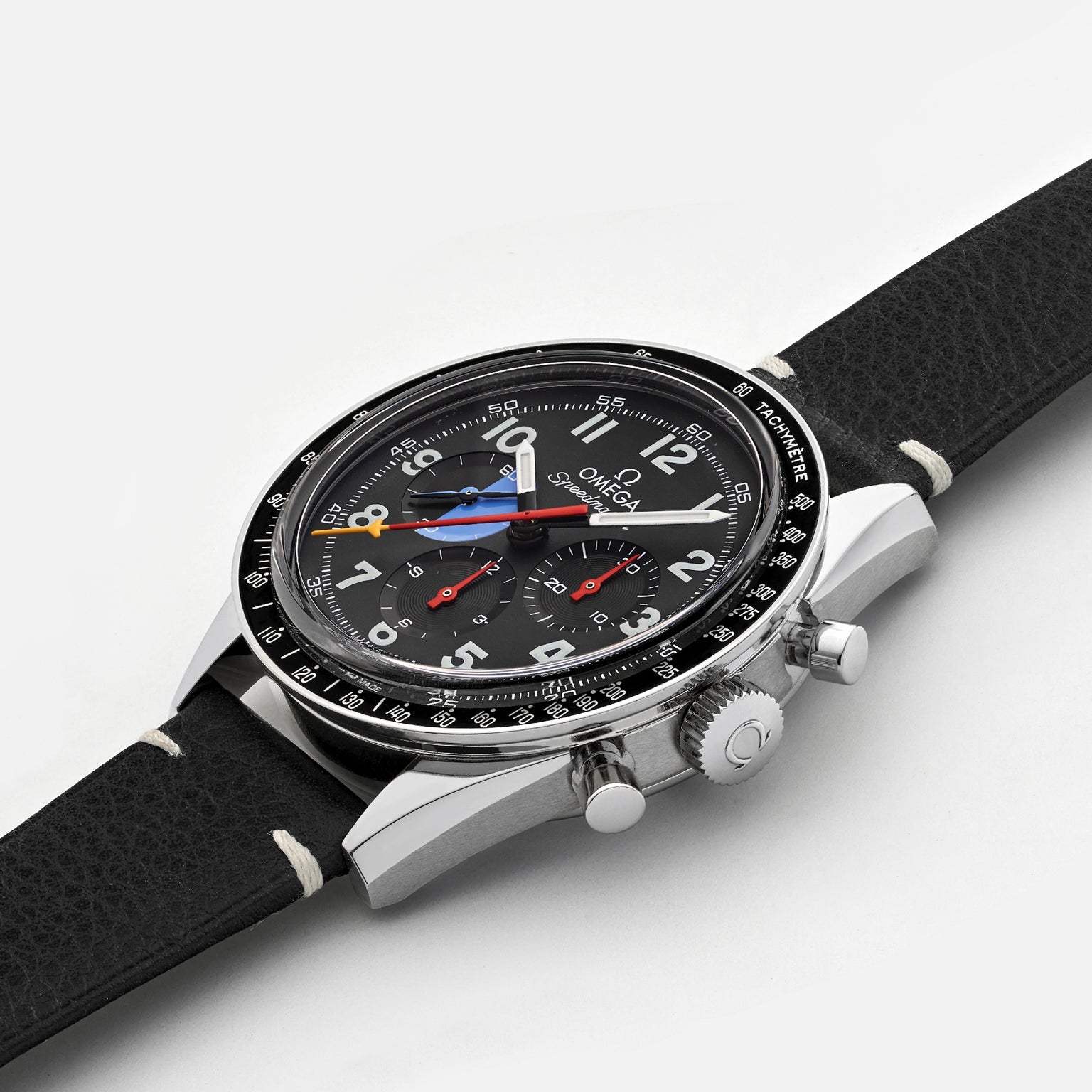 The OMEGA Speedmaster Hodinkee 10th Anniversary Limited Edition chronograph wristwatch features a black leather strap, silver case, and multiple dials with precise movement, shown on a plain white background.