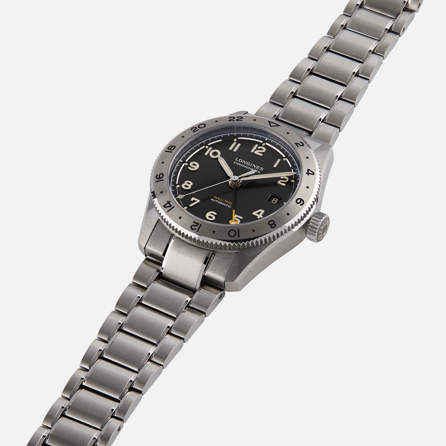 The Longines Spirit Zulu Time Limited Edition For Hodinkee is a stainless steel wristwatch featuring a black dial, silver hour markers, and a metal link bracelet, shown here on a white background.