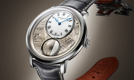 Luxury wristwatch with a textured metallic dial, Roman numerals, and a black leather strap on a brown background.