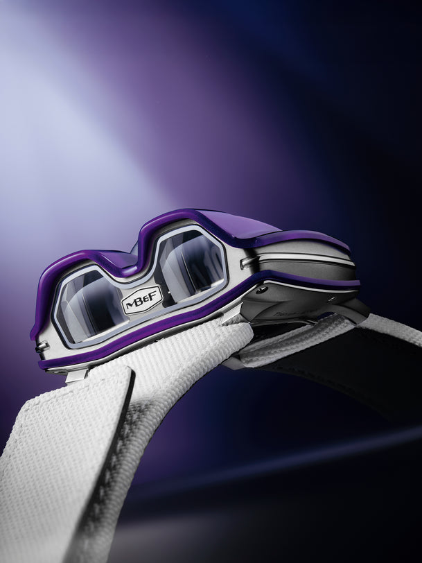 The MB&F HM8 Mark 2 Titanium Limited Edition watch in futuristic purple and silver with a white strap, set against a blurred purple background.